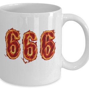 May include: White ceramic coffee mug with the number 666 in a fiery orange and yellow design.