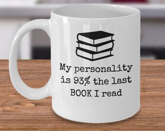 May include: White ceramic coffee mug with a black graphic of a stack of books and the text "My personality is 93% the last BOOK I read".