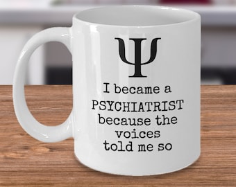 Puede incluir: Taza de café de cerámica blanca con un símbolo "Ψ" negro y el texto "Me convertí en PSIQUIATRA porque las voces me lo dijeron."