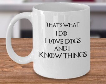 May include: White ceramic coffee mug with a black graphic that reads "That's what I do I love dogs and I know things".