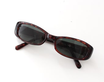 Könnte beinhalten: Rechteckige Sonnenbrille in Schildpatt-Optik mit dunklen Gläsern.