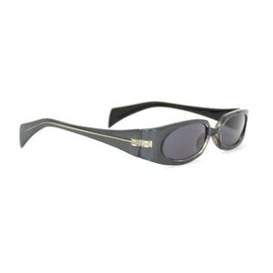 May include: Dark gray oval sunglasses with black temples and dark lenses. The sunglasses have a silver accent on the temples and a silver hinge detail. The sunglasses are set against a white background.