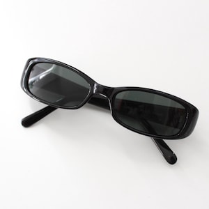 May include: Black rectangular sunglasses with dark lenses.