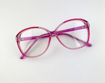 May include: A pair of pink plastic framed eyeglasses with clear lenses.