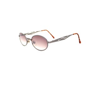 Pode incluir: Um par de &oacute;culos de sol ovais com arma&ccedil;&atilde;o de metal prateado e lentes marrons. A arma&ccedil;&atilde;o tem um design decorativo nas hastes.