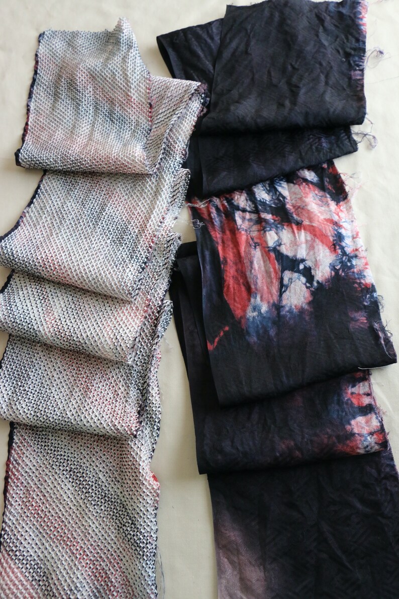 May include: Two fabric strips, one with a white and pink woven pattern and the other with a black and red tie-dye pattern.