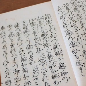 Könnte beinhalten: Eine Seite aus einem Buch, das in japanischer Sprache geschrieben ist. Der Text ist in schwarzer Tinte auf weißem Papier. Die Seite ist auf einen Abschnitt des Buches geöffnet, der ein Gedicht oder eine Geschichte zu sein scheint.