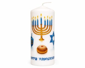 May include: A white cylindrical pillar candle featuring a gold menorah with blue flames, a blue Star of David, a blue dreidel, and a round jelly donut. The text "HAPPY HANUKKAH" is printed in blue at the bottom of the candle surface.