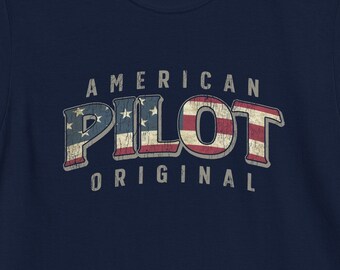 Puede incluir: Camiseta azul marino con un diseño de bandera estadounidense desgastado y el texto "AMERICAN PILOT ORIGINAL".