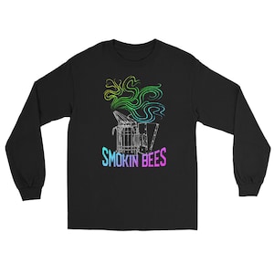 May include: A black long-sleeve shirt featuring a white line-art graphic of a bee smoker emitting swirling smoke in a gradient of green, yellow, and blue. Below the graphic, the text SMOKIN BEES is printed in a vibrant, multi-colored gradient.