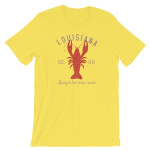 Op de afbeelding: Geel T-shirt met een rode kreeft afbeelding en de tekst "Louisiana Est. 1812" en "Laissez le bon temps rouler".