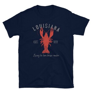 May include: A navy blue t-shirt with a distressed white graphic of a crawfish and the text "Louisiana Est. 1812" and the phrase "Laissez les bon temps rouler".