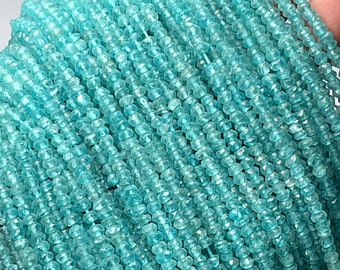 Könnte beinhalten: Eine Strähne aus hellblauen Edelsteinperlen. Die Perlen sind facettiert und haben eine leicht unregelmäßige Form. Die Perlen sind auf einem durchsichtigen Faden aufgefädelt.