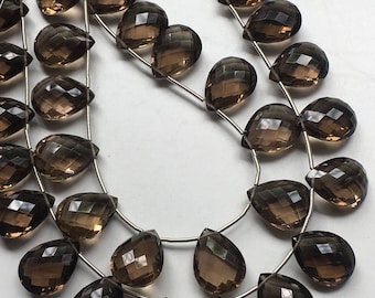 May include: Strands of faceted, teardrop-shaped smoky quartz beads. The beads are a translucent brown color and strung on thin, silver-colored wire. The beads have a polished, reflective surface, and are arranged in multiple strands.