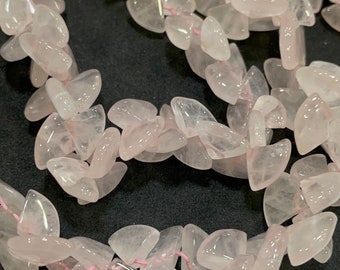 May include: Strands of polished, pale pink rose quartz gemstone chips. The irregular, petal-shaped stones are strung on a thin, pink cord, creating a delicate and natural aesthetic. Ideal for jewelry making or craft projects.