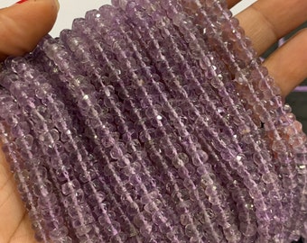 Könnte beinhalten: Eine Strähne aus helllila Amethystperlen, facettiert und auf einem Faden aufgereiht. Die Perlen sind klein und gleichmäßig in der Größe, was einen zarten und eleganten Look erzeugt.