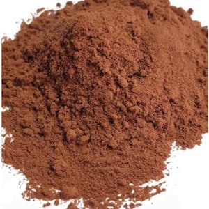 Peut inclure: Gros plan sur un tas de poudre de cacao brun foncé. La poudre est finement moulue et a une couleur riche et chocolatée.