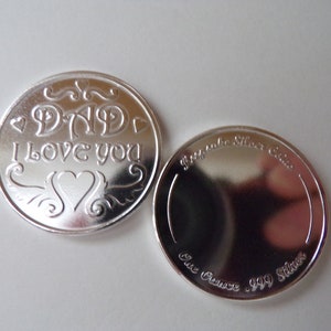 May include: Silver coin with the inscription "Dad I love you" on one side and "One Ounce .999 Silver" on the other side.