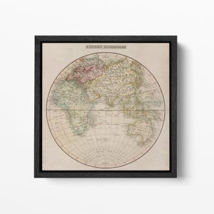 Könnte beinhalten: Gerahmter Vintage-Karten-Druck der östlichen Hemisphäre. Die Karte zeigt detaillierte geografische Informationen, wobei verschiedene Regionen durch verschiedene Farben hervorgehoben werden. Der Druck ist in einem schwarzen Rahmen eingefasst und schafft ein klassisches und dekoratives Stück.