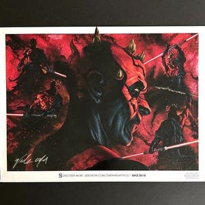 Puede incluir: Una impresión artística de Star Wars que presenta a Darth Maul de perfil, con múltiples imágenes de él empuñando un sable de luz rojo sobre un fondo rojo y negro. La impresión incluye la firma del artista y el logotipo de Star Wars.