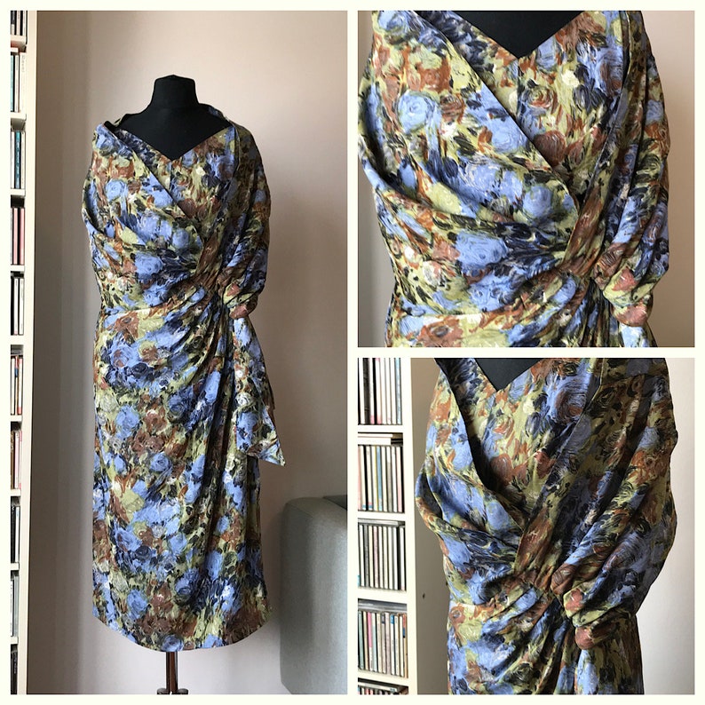 May include: A blue, green, and brown floral print dress with a wrap style and a knotted detail at the waist.