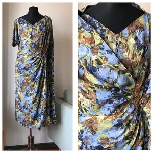 May include: A blue, green, and brown floral print dress with a draped neckline and short sleeves.