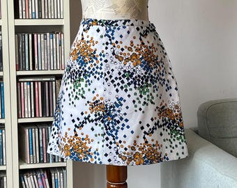 Minigonna a trapezio vintage anni '60 con stampa geometrica colorata; gonna a vita alta di tendenza in stile mod.