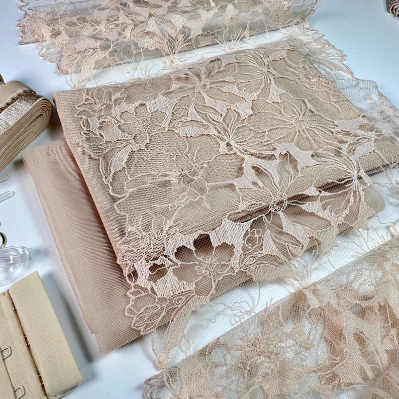 Puede incluir: Un conjunto de tela de encaje beige, con un patr&oacute;n floral, y una cinta beige. La tela es perfecta para proyectos de artesan&iacute;a y costura.