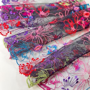 May include: Black mesh fabric with colourful embroidered floral designs. The flowers are in shades of pink, red, purple, blue, and green.