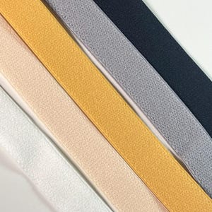 May include: A selection of elastic bands in a variety of colours, including white, beige, gold, grey, and navy. The bands have a textured surface and are arranged diagonally, displaying a range of shades and textures.