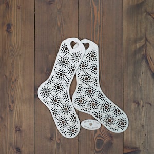 May include: Two white wooden sock blockers with a heart-shaped cutout and a repeating circle pattern. The blockers are on a brown wooden surface. The text "Made with ♥ Mylnadrow" is printed on a small wooden tag.