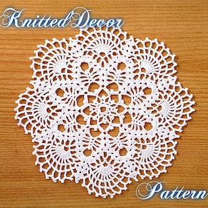 May include: White crocheted doily with a delicate, intricate design. The doily is circular and has a center with a flower-like pattern. The doily is on a wooden surface.