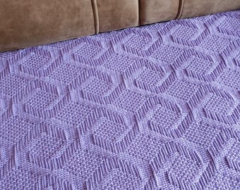 May include: A lavender crochet blanket featuring a repeating geometric pattern of raised, textured lines that form interconnected square shapes across the entire surface, creating a dense, tactile, and uniform design throughout the fabric.