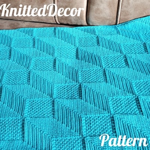 May include: A teal blue knitted blanket with a geometric pattern. The blanket is made with a textured stitch and has a square shape. The text "Knitted Decor Pattern" is visible in the bottom right corner of the image.