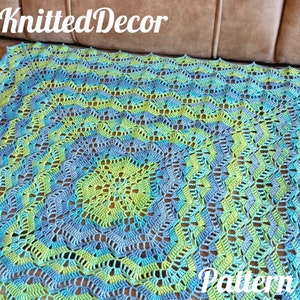 May include: A crocheted square blanket in shades of blue, green, and teal. The blanket has a lacy pattern and a scalloped edge. The text "Knitted Decor Pattern" is visible in the bottom right corner of the image.