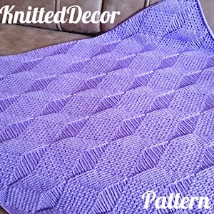 May include: A purple knitted blanket with a diamond pattern. The blanket is on a brown couch. The text "Knitted Decor Pattern" is visible in the image.