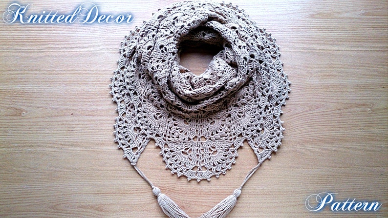 May include: A beige, crocheted shawl with a circular design and tassel accents. The shawl is made of a soft, textured yarn and features intricate openwork patterns. The text "Knitted Decor" and "Pattern" are visible.