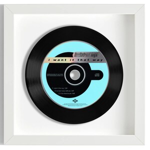 May include: A framed black and white 7-inch vinyl record with a blue and white label. The label features the text "Backstreet Boys" and "I want it that way".