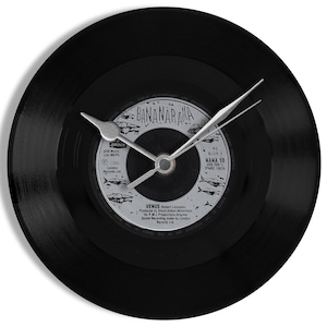 May include: A black vinyl record clock featuring a 7-inch single by Bananarama, titled "Venus". The clock hands are silver and the record label is white with black text.