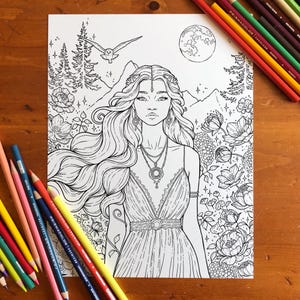 Puede incluir: Página para colorear en blanco y negro con una mujer de largo cabello suelto, un vestido y joyas, rodeada de flores, árboles y una luna llena. Lápices de colores visibles sobre la superficie de madera.