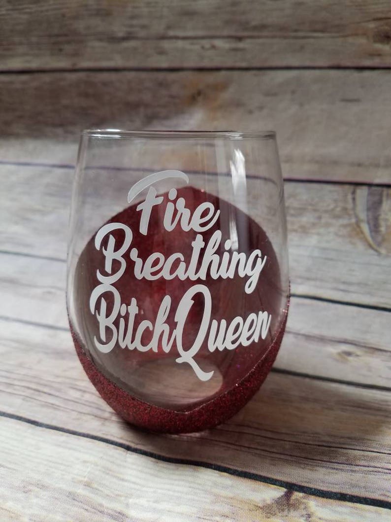 May include: A red glitter wine glass with the text "Fire Breathing Bitch Queen" etched on the side.