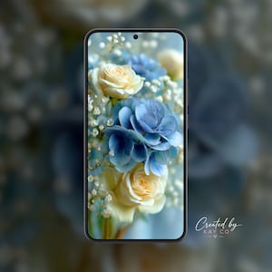 May include: A smartphone with a black frame displaying a floral wallpaper featuring cream-colored roses, blue hydrangea blossoms, and small white baby's breath flowers. The screen has a centered front-facing camera hole at the top edge of the device.