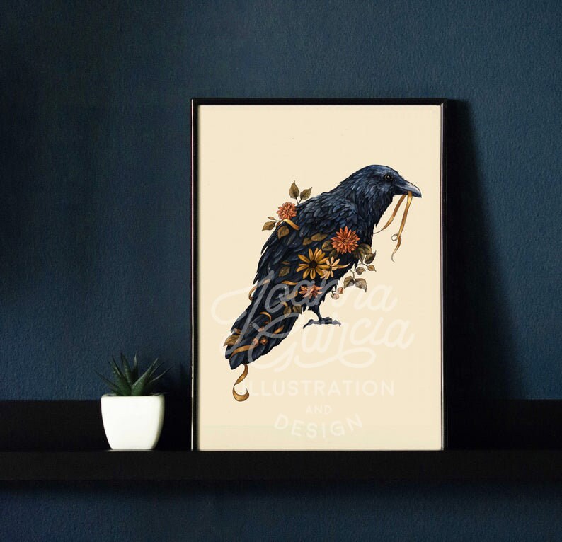 May include: A black raven with a yellow ribbon in its beak, surrounded by orange and yellow flowers. The raven is perched on a branch with its wings spread out. The background is a light cream color. The image is titled "Joanna Garcia Illustration and Design".