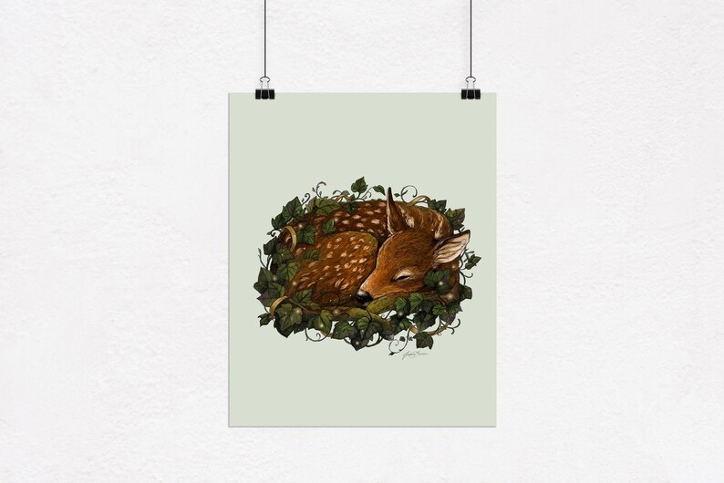 May include: A brown and white spotted fawn sleeping curled up in a nest of green ivy.