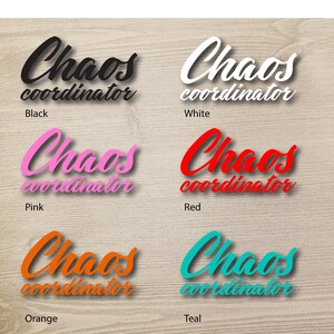 Könnte beinhalten: Sechs verschiedene Farbvarianten eines Vinyl-Aufklebers mit dem Text "Chaos Coordinator" in einer kursiv geschriebenen Schrift. Die Farben sind Schwarz, Weiß, Rosa, Rot, Orange und Türkis.