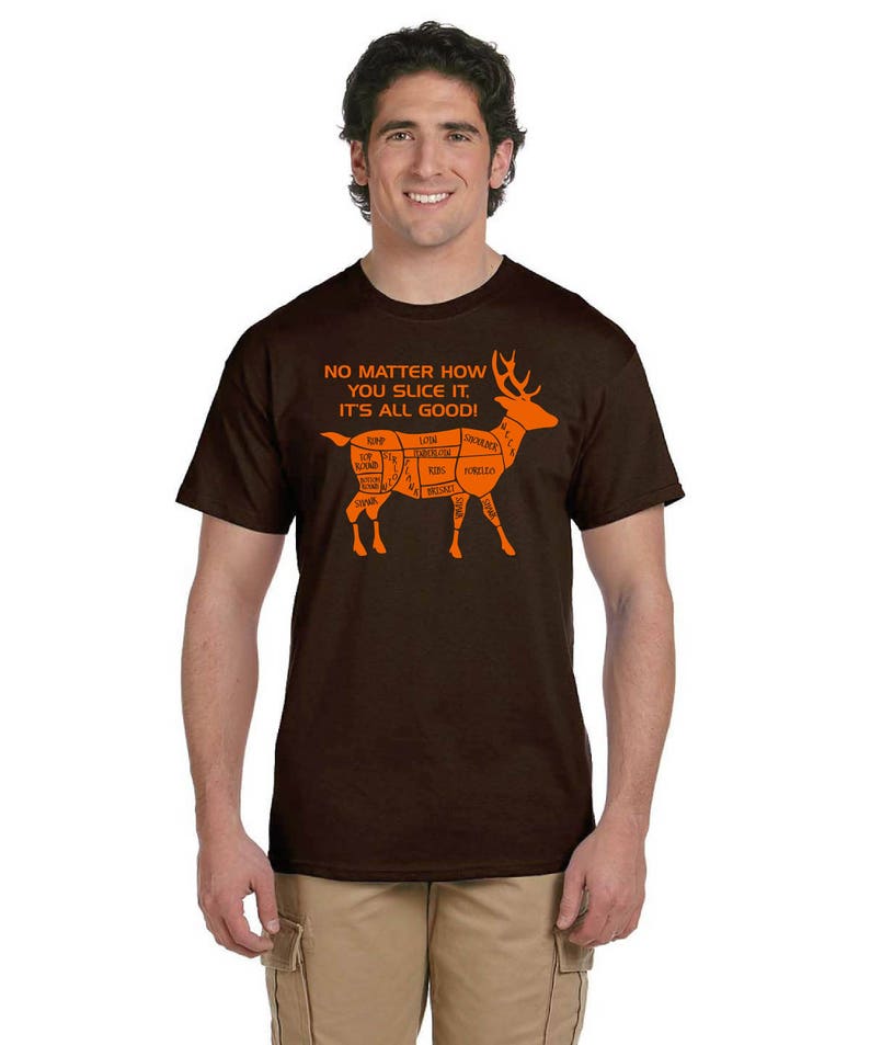 May include: A brown t-shirt with an orange deer graphic. The deer is labeled with different cuts of meat. The text on the shirt reads "No matter how you slice it, it's all good!"
