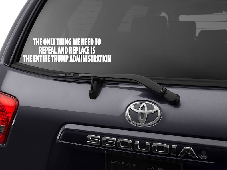May include: A black SUV with a white vinyl sticker on the rear window that reads "THE ONLY THING WE NEED TO REPEAL AND REPLACE IS THE ENTIRE TRUMP ADMINISTRATION". The vehicle has a chrome "SEQUOIA" emblem on the rear.