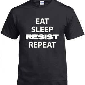 May include: Black t-shirt with white text that reads "Eat Sleep Resist Repeat".