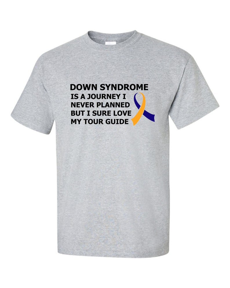 Op de afbeelding: Grijs T-shirt met de tekst "Down Syndrome is a journey I never planned but I sure love my tour guide" en een geel en blauw lint.