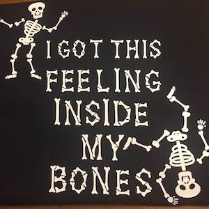 May include: Black t-shirt with a white skeleton graphic and the text "I got this feeling inside my bones".